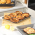 Tray of six homemade Yorkshire puddings cooled on a baking tray in a modern kitchen