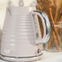 Pink ribbed electric kettle with chrome handle on kitchen countertop