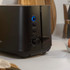 Black 2-slice toaster with cancel, reheat, and defrost buttons on a kitchen counter