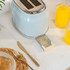 Light blue two-slice toaster with removable crumb tray on a kitchen counter