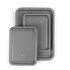 Set of three grey non-stick roasting trays, nested, viewed from above.