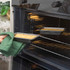 Non-stick loaf tin with crumble topping being placed in an oven, kitchen setting.