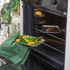 Set of two grey baking trays with food, shown on kitchen worktop