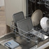 Grey baking trays and plates loaded in dishwasher rack