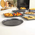 Set of black non-stick baking trays with food, assorted shapes for roasting, baking, and pizza.