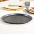 Black speckled round pizza tray shown empty on kitchen counter