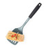 Blue slotted spatula with black handle holding a cooked salmon fillet with herbs and red chilli garnish