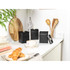 Set of three black kitchen storage canisters with lids on a white worktop