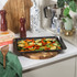Black baking tray with roasted mixed vegetables on kitchen worktop