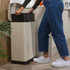 Cream pedal bin in kitchen, person lifting black inner tray for recycling or waste sorting