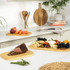 Wooden chopping boards with roast beef, vegetables, and cheese platter on kitchen counter