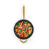 Stir fry with vegetables and chicken in a black frying pan with gold handles, top view
