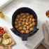 Cooked chicken pieces in air fryer basket on kitchen worktop