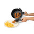 Air fryer basket serving breaded chicken strips and chips onto a plate