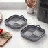 Set of two grey silicone air fryer liners with handles on kitchen worktop