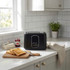 Black two-slice toaster on kitchen counter with toast and strawberry jam