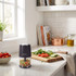 Black electric mini chopper with mixed vegetables, shown on kitchen worktop