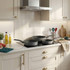 Set of three grey frying pans on a modern kitchen hob, shown from above.