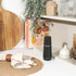Black electric salt or pepper grinder seasoning salmon fillet and vegetables on plate