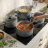 Set of grey non-stick saucepans in use on hob, ideal for cooking pasta and sauces