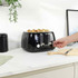 Black 4-slice toaster with toast, shown in use on kitchen worktop