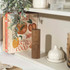 Acacia wood salt mill on shelf beside recipe books and kitchen accessories