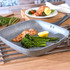 Grey square grill pan with cooked salmon fillet, broccolini, asparagus, and lemon wedge