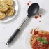 Silver and black serving spoon beside plate of garlic bread and spaghetti in tomato sauce