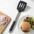 Black and silver slotted spatula next to chopped onion and cheeseburger meal