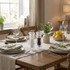 Table setting with clear salt and pepper mills, herbs, and lemons in natural light