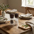 Set of Salter salt and pepper grinders on rustic dining table, natural wood lids.