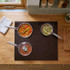 Induction hob with three silver saucepans cooking colourful vegetables and rice