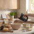 Black Salter hand mixer whisking bread dough in kitchen, bowl and flour visible