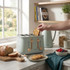 Sage green four-slice toaster on kitchen counter with toast and bread