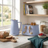 Blue kettle and toaster set on kitchen counter, bread and berries nearby