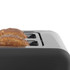 Grey toaster with two slices of multigrain bread toasting, shown from the side.