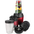 Red personal blender with cup containing assorted fruit and greens, three spare cups and lids.