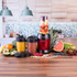 Red Salter Nutri Pro blender with fruit-filled jug, two smoothie cups, assorted fresh fruit.