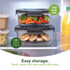 Glass lunchbox filled with mixed roasted vegetables on kitchen counter, shown in use.