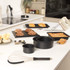 Black round and rectangular non-stick baking tins on kitchen counter with baked goods