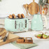 Mint green 4-slice toaster and kettle set on kitchen counter with bread and breakfast.