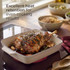 Cream ceramic roasting dish with cooked vegetables and sausages on stovetop, hand using tongs