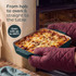 Rectangular green roasting dish with cooked chicken and vegetables on kitchen hob