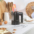 Black hand mixer with stand on kitchen counter, beaters and dough hooks shown
