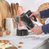 Black hand mixer with chrome beaters and accessories on kitchen counter