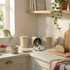 Set of three beige kitchen canisters with bamboo lids on marble worktop, one open with tea bags