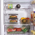 Stacked glass food containers in fridge with fresh salmon, vegetables and salad