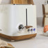 White toaster with wood-effect trim and controls, shown on a kitchen worktop