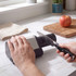 Electric knife sharpener in use on kitchen counter