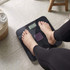 Black digital bathroom scale in use, showing weight reading on display